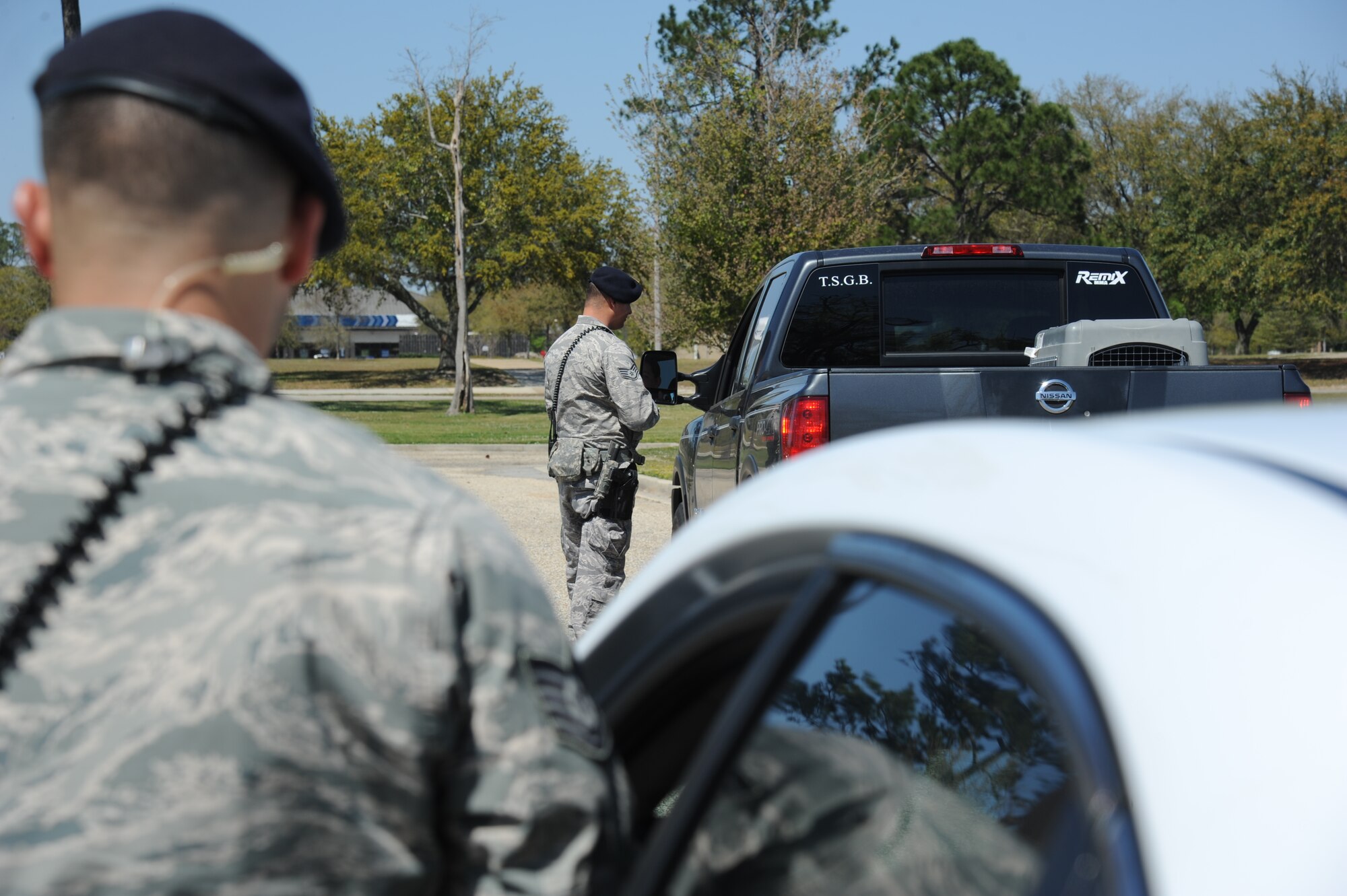 Tech. Sgt. Benjamin Collins, 81st Security Forces Squadron, stands by as Staff Sgt. Jose Orama, 81st SFS, checks a driver’s credentials during a traffic stop March 25, 2013, at Keesler Air Force Base, Miss.  The 81st SFS offers a ride-along program for anyone interested in learning more about Air Force law enforcement.  (U.S. Air Force photo by Kemberly Groue)