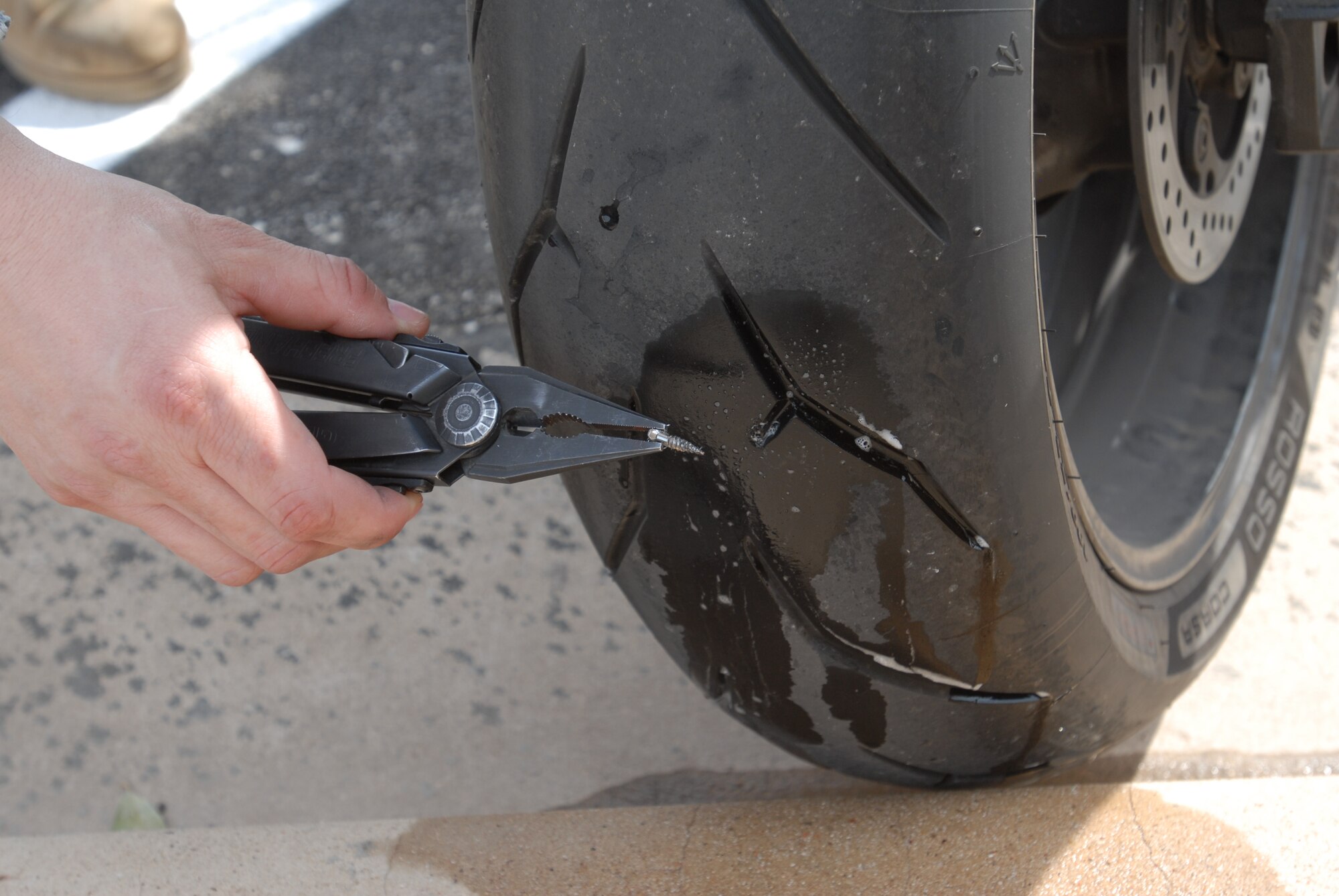 GOODFELLOW AIR FORCE BASE, Texas – Army 1st Lt. Michael J. Fijman, Army 344th Military Intelligence Battalion Safety Officer, finds a screw in his tire while performing a mandatory maintenance check on his motorcycle March 22 at the Army battalion here. This maintenance checklist is one of the ways to practice safety awareness when riding motorcycles.  (U.S. Air Force photo/ Airman 1st Class Breonna Fields)
