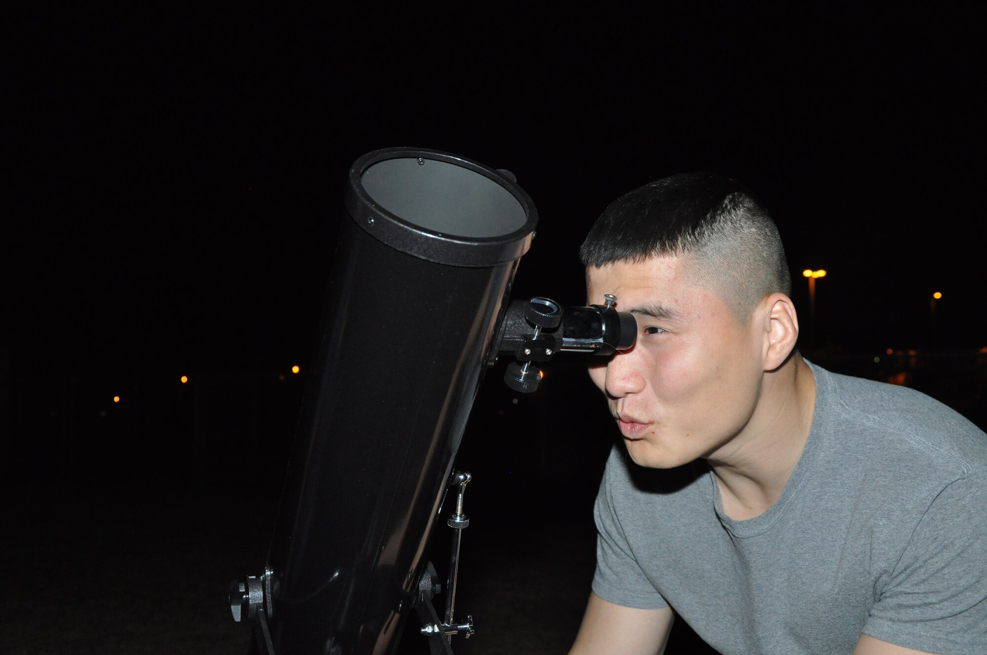 GOODFELLOW AIR FORCE BASE, Texas—Airman 1st Class Aziz Sarbashev, 17th Force Support Squadron personnel technician, uses a telescope to gaze at the moon during the Stargazer Party at the Youth Softball Field March 23. The base library provided two telescopes and one group of participants even brought their own telescope. (U.S. Air Force photo/Airman Jessica Keith)