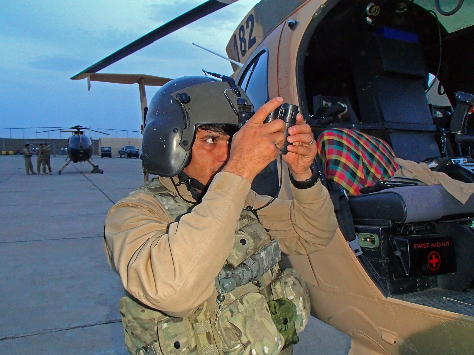 Afghan Air Force 1st Lt. Maiwand checks his night vision goggles prior to a nighttime training mission March 19, 2013, at Shindand Air Base, Afghanistan. The current class going through NVG training, with eight students, is the largest class as well as only the third class to go through the training at SAB. NVG training is taught by air advisors from the 444th Air Expeditionary Advisory Squadron. (U.S. Air Force photo/Capt. Anastasia Wasem)