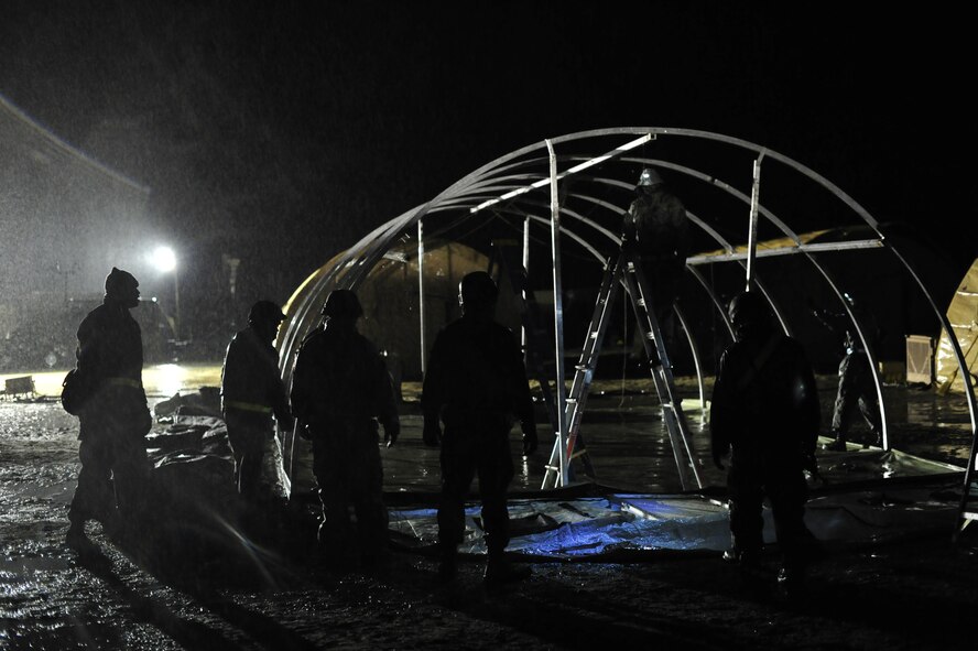 JOINT BASE MCGUIRE-DIX-LAKEHURST, N.J. -- U.S. Air Force Airmen assigned to the 621st Contingency Response Wing at JB MDL, build tents to sleep in on the first night of their participation in Exercise Eagle Flag 13-2 at Lakehurst.  Approximately  150 Airmen from the CRW and U.S. Army Soldiers from the 690th Rapid Port Opening Element, based at Joint Base Langley-Eustis, Va., were part of U.S. Transportation Command Joint Task Force validation exercise March 18 to 22, 2013. (U.S. Air Force photo by Tech. Sgt. Parker Gyokeres/Released)