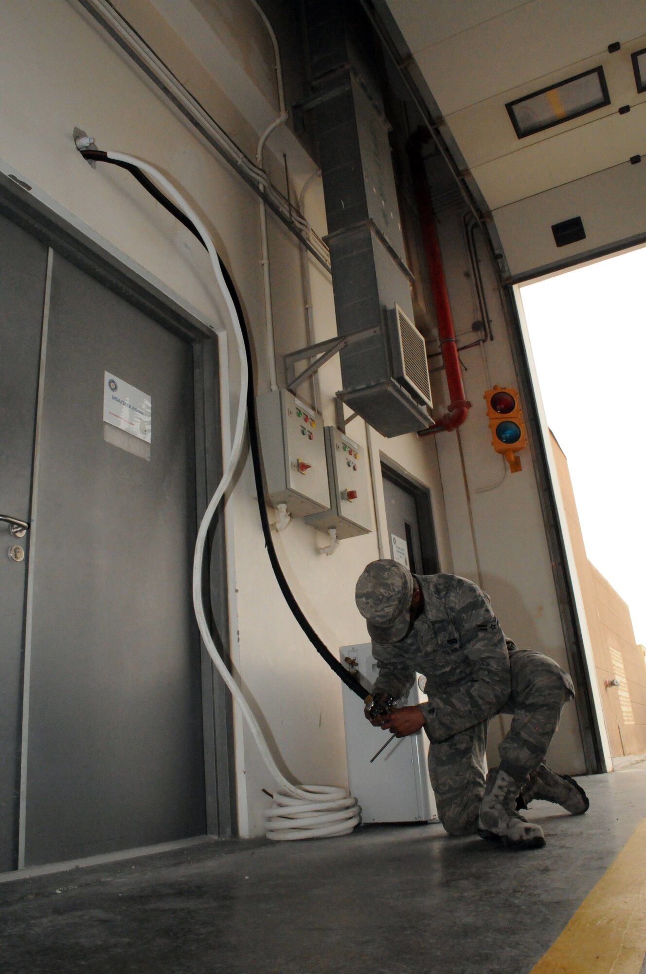 SOUTHWEST ASIA -- Airman 1st Class Jeremiah May connects the refrigerant lines for a split system air conditioner at the fire department, March 21. The 379th Expeditionary Civil Engineer Squadron Heating Ventilation Air Conditioning / Refrigeration shop maintains all wing and tenant HVAC/R systems on base. (U.S. Air Force photo/Master Sgt. Christian Michael)