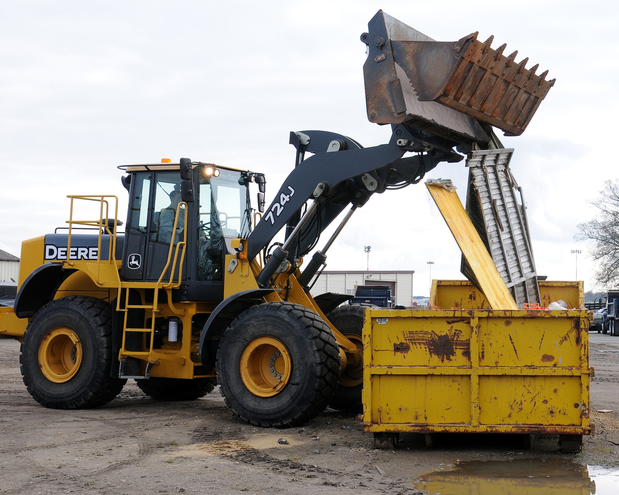 Airman 1st Class Michael Sternberg, 100th Civil Engineer Squadron Pavements and Construction equipment operator "Dirt boy" from Panhandle, Texas, uses a front-end loader to dispose of wood in a skip prior to its removal off-base March 21, 2013, at RAF Mildenhall, England. Front-end loaders are multi-purpose machines that are used for excavation, fork-lift operations and general construction. The term “Dirt boyz” is a slang term used among those in RED HORSE. It is similar to a term of endearment-one that is said with respect, admiration and distinction throughout the civil engineer career field. (U.S. Air Force photo by Gina Randall/Released)