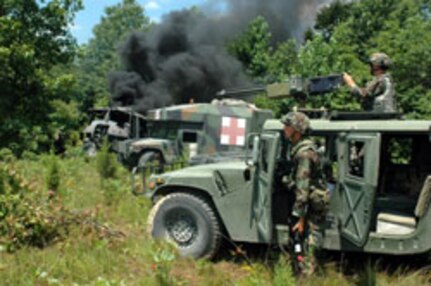 Members of the Indiana Army National Guard's 1st Battalion, 293rd Infantry, 76th Infantry Brigade Combat Team guard the perimeter after a simulated helicopter crash during XCTC 2006 at Camp Atterbury, Ind., in July.