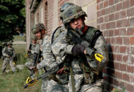 Soldiers of the 56th Brigade, 36th Infantry Division, Texas Army National Guard, prepare to enter and clear a building during a field training exercise with the British Territorial Army in the Salisbury Plain training area located in southern England.