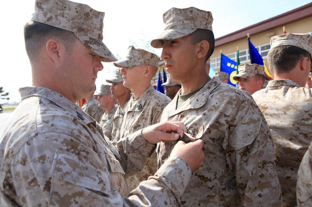 Petty Officer 1st Class Adam Clayton, an instructor with Field Medical Training Battalion West, 30, from Salt Lake City, Utah, pins a Corpsmen Shield on a sailor who completed the corpsmen school at Camp Pendleton, Calif., March 22. The shield signifies they have become certified field medical technicians.


