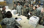 Maj. Lynn Pate (left) speaks to the 11-soldier all-female security assistance team during the first day of mobilization processing at the Ft. Pierce National Guard Armory Monday. The small team of female soldiers will be attached to the 2nd Battalion, 124th Infantry Regiment security force assembling at Camp Shelby, Miss., before deploying to Iraq later this year.