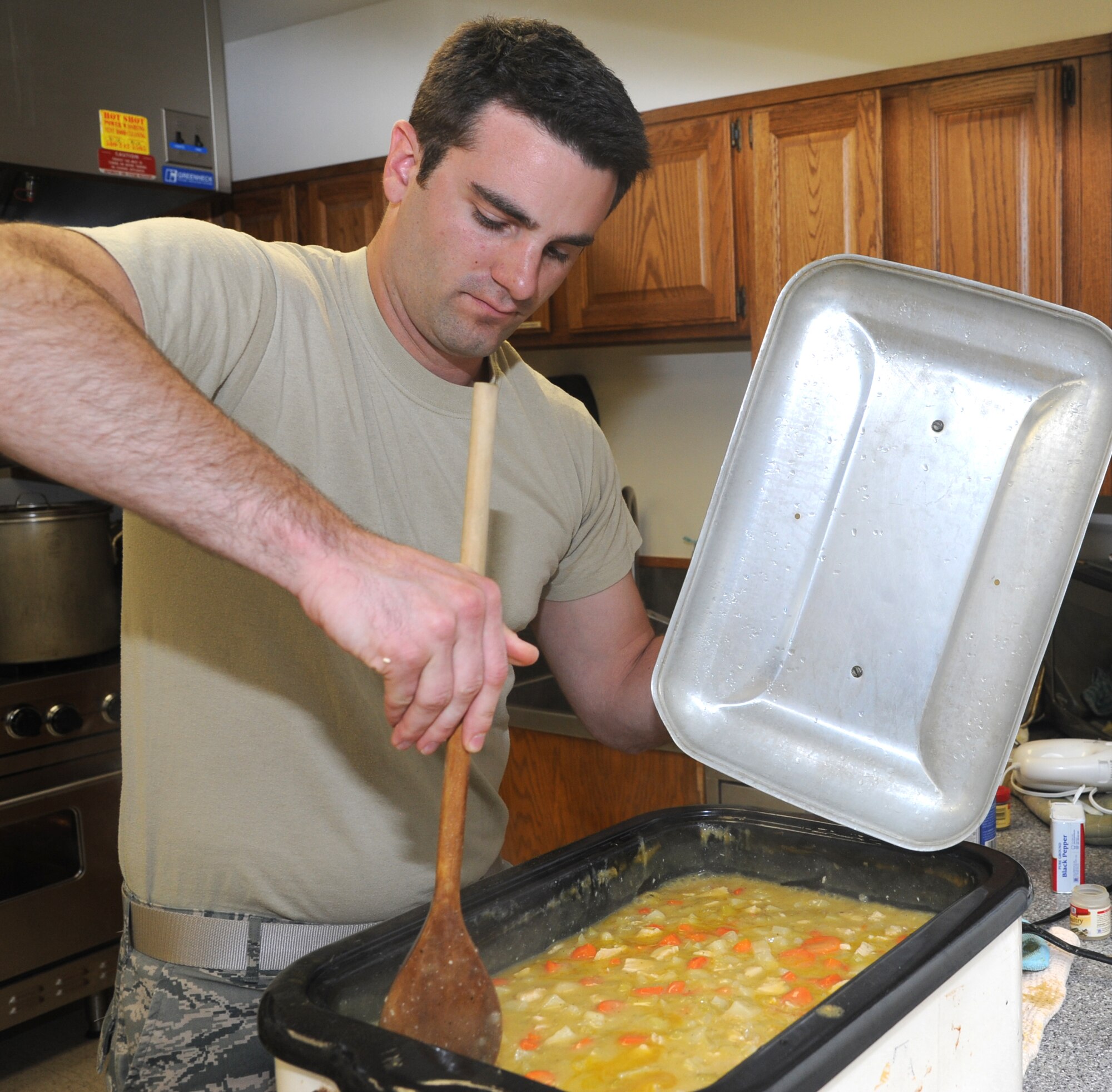 2nd Lt. Andrew Banks, with the 71st Student Squadron, stirs vegetable stew in preparation for the Singles’ International Gourmet Meal Opportunity March 25 in the Community Chapel Activity Center at Vance Air Force Base, Okla. (U.S. Air Force photo/ Senior Airman Frank Casciotta)