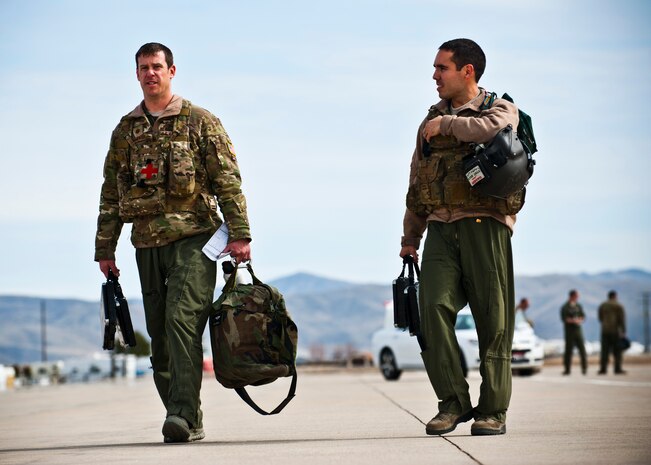 U.S. Air Force Maj. Nathan Nowaski and Capt. Anibal Aguirre step from their aircraft during the terminal employment phase March 19, 2013, at Gowen Field, Idaho. Four students assigned to the U.S. Air Force Weapons School went through two weeks of rigorous training scenarios to display maximum combat effectiveness to instructor pilots. The "T.E." mission objective is to demonstrate and instruct HH-60 Pave Hawk weapons employment and landing zone options to U.S. Air Force Weapons School students by maximizing weapons proficiency and quickly recover survivors. The phase is one out of a series of advanced training programs administered at the USAF Weapons School located at Nellis Air Force Base, Nev. (U.S. Air Force photo by Senior Airman Brett Clashman)