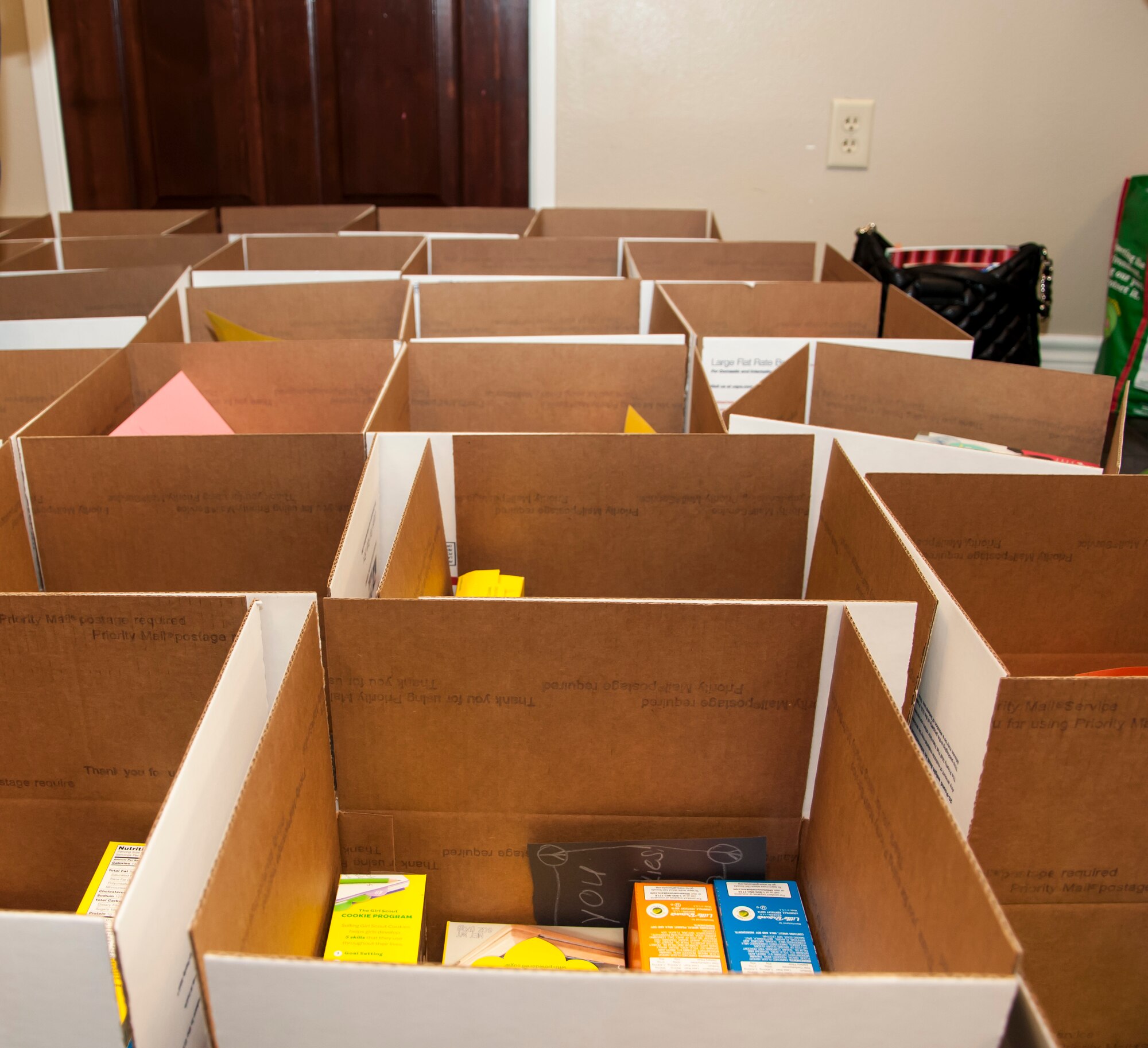 Packages with cookies and thank you cards are stacked side-by-side at Laughlin Air Force Base, Texas, on March 21, 2013. The packages were sent to deployed Laughlin troops and were prepared by Girl Scout Troop 1168 members.