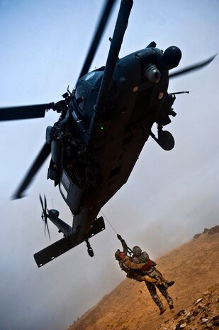 A U.S. Air Force pararescueman hoists a survivor underneath an HH-60 Pave Hawk during the terminal employment phase March 13, 2013, at the Orchard Combat Training Center, Idaho. The hoist is a quick, effective method of recovering survivors.  The "T.E." mission objective is to demonstrate and instruct HH-60 Pave Hawk weapons employment and landing zone options to U.S. Air Force Weapons School students by maximizing weapons proficiency and quickly recover survivors. The phase is one out of a series of advanced training programs administered at the USAF Weapons School located at Nellis Air Force Base, Nev. (U.S. Air Force photo by Senior Airman Brett Clashman)