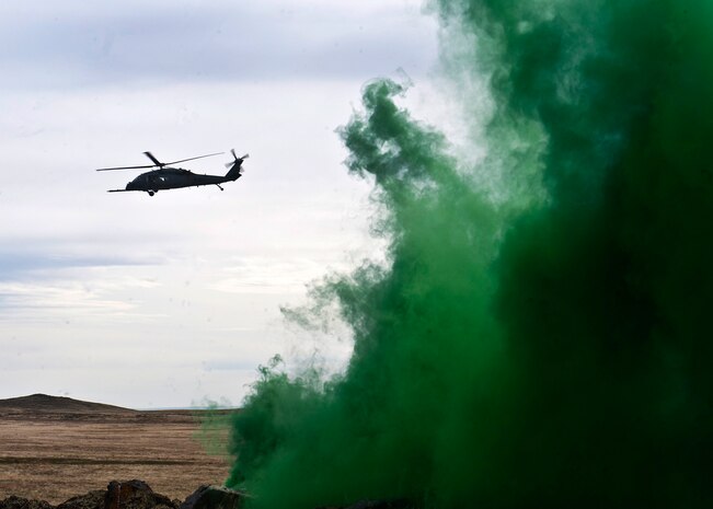 A U.S. Air Force HH-60 Pave Hawk identifies the landing zone from green smoke during the terminal employment phase March 13, 2013, at the Orchard Combat Training Center, Idaho. The "T.E." mission objective is to demonstrate and instruct HH-60 Pave Hawk weapons employment and landing zone options to U.S. Air Force Weapons School students by maximizing weapons proficiency and quickly recover survivors. The phase is one out of a series of advanced training programs administered at the USAF Weapons School located at Nellis Air Force Base, Nev. (U.S. Air Force photo by Senior Airman Brett Clashman)