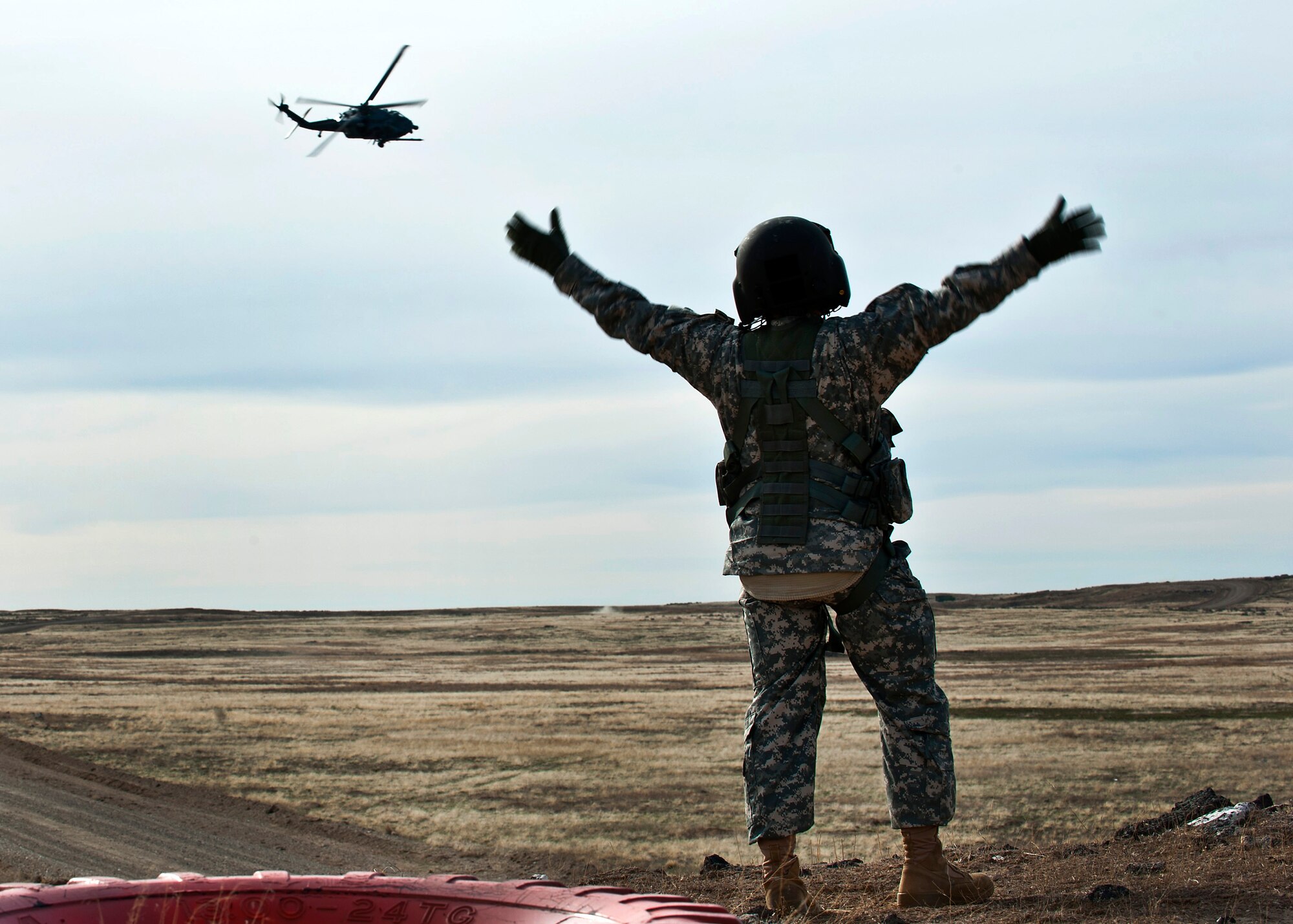 A survivor signals an HH-60 Pave Hawk for rescue during the terminal employment phase March 13, 2013, at the Orchard Combat Training Center, Idaho. The "T.E." mission objective is to demonstrate and instruct HH-60 Pave Hawk weapons employment and landing zone options to U.S. Air Force Weapons School students by maximizing weapons proficiency and quickly recover survivors. The phase is one out of a series of advanced training programs administered at the USAF Weapons School located at Nellis Air Force Base, Nev. (U.S. Air Force photo by Senior Airman Brett Clashman)