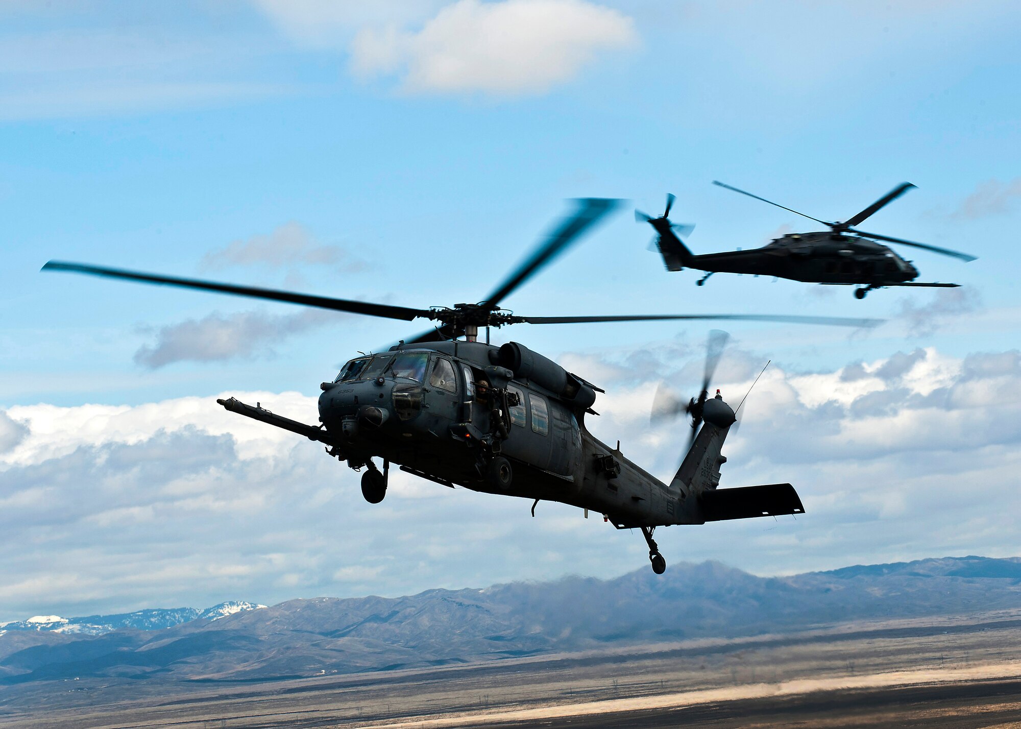 A U.S. Air Force HH-60 Pave Hawk prepares to land while another provides security during the terminal employment phase March 11, 2013, at the Orchard Combat Training Center, Idaho. The Pave Hawk's core ability is recovery of service members under stressful conditions, including search and rescue. The "T.E." mission objective is to demonstrate and instruct HH-60 Pave Hawk weapons employment and landing zone options to U.S. Air Force Weapons School students by maximizing weapons proficiency and quickly recover survivors. The phase is one out of a series of advanced training programs administered at the USAF Weapons School located at Nellis Air Force Base, Nev. (U.S. Air Force photo by Senior Airman Brett Clashman)