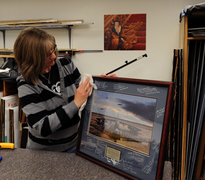 Brenda Porter, Arts and Crafts frame shop, applies the finishing touches to a gift on Barksdale Air Force Base, La., March 27. The frame shop constructs and sells its own frames allowing Airmen to pick and choose the style of frame they would like to use to house a photo. (U.S. Air Force photo/Airman 1st Class Benjamin Gonsier)