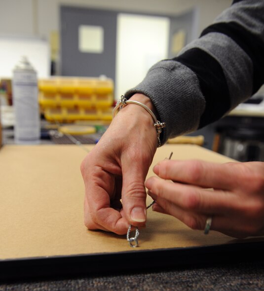 Brenda Porter, Arts and Crafts frame shop, places a hanging wire behind a picture frame on Barksdale Air Force Base, La., March 27. The frame shop is open Monday to Friday from 9 a.m. to 5 p.m. (U.S. Air Force photo/Airman 1st Class Benjamin Gonsier)