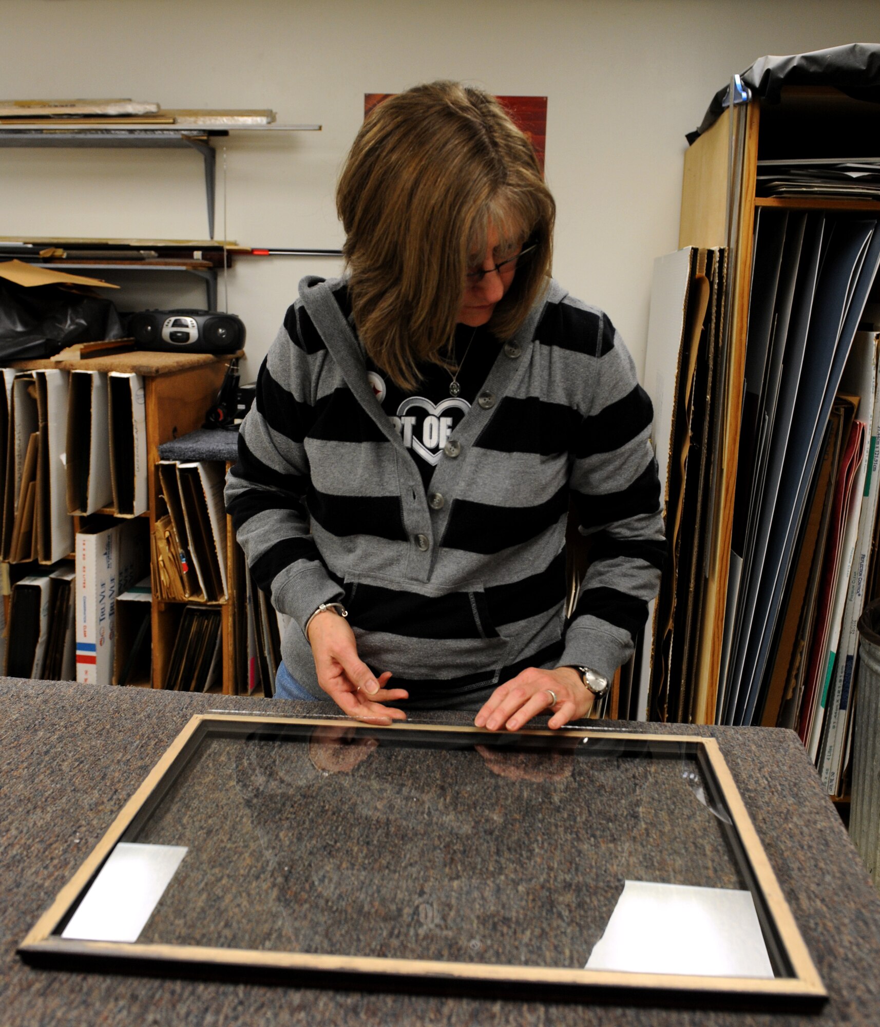 Brenda Porter, Arts and Crafts frame shop, compares a piece of glass to a frame on Barksdale Air Force Base, La., March 27. The frame shop works on more than 20 projects a week. (U.S. Air Force photo/Airman 1st Class Benjamin Gonsier)