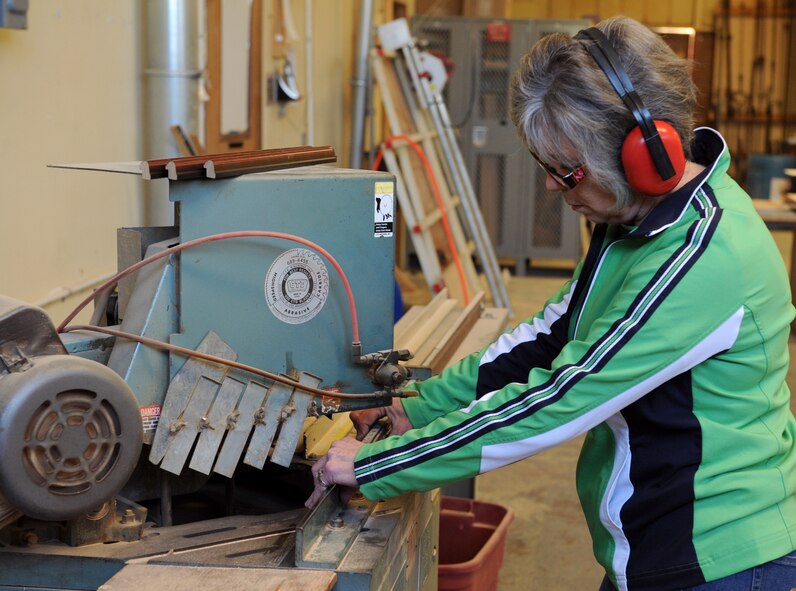 Bobbie Romano, Arts and Crafts frame shop, cuts a piece of frame mold on Barksdale Air Force Base, La., March 27. The frame shop constructs and sells its own frames allowing Airmen to pick and choose the style of frame they would like to use to house a photo. (U.S. Air Force photo/Airman 1st Class Benjamin Gonsier)