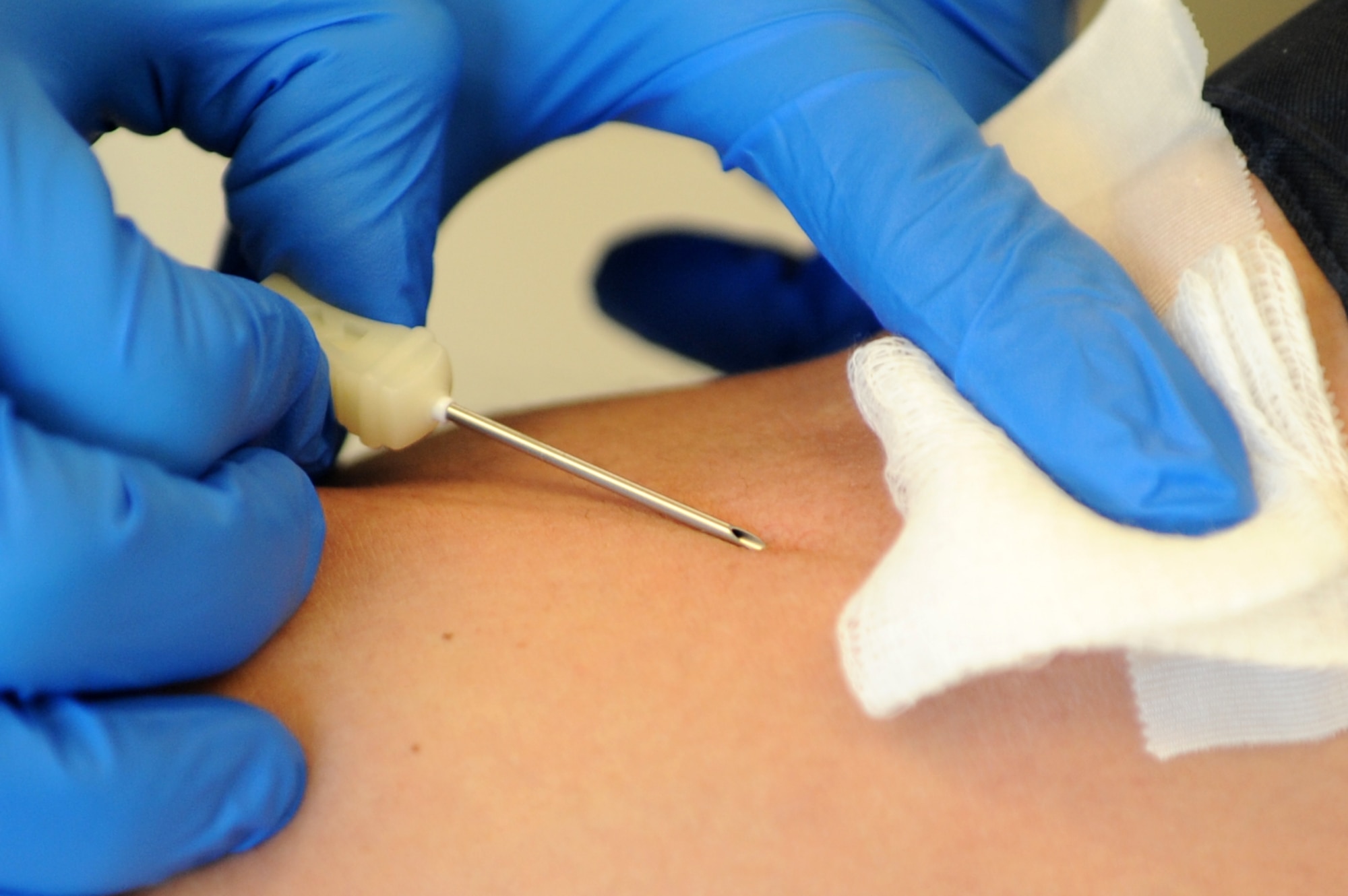 A needle penetrates the arm of a Team Buckley member March 20, 2013, at the Children’s Hospital Colorado in Denver. The 460th Space Communications Squadron participated as a group to donate to the children’s hospital. Every year, 8,000 units of blood products are transfused into sick and injured infants, children and teen patients who receive treatment at the hospital. (U.S. Air Force photo by Senior Airman Marcy Glass/Released)