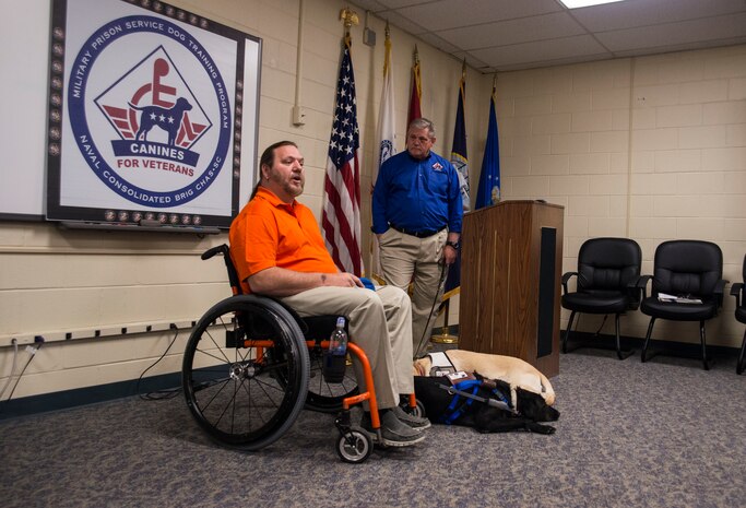 Rick Hayes, an Air Force veteran, addresses guests after being presented Malachi, his new service dog, during a ceremony March 21, 2013, at the Naval Consolidated Brig Charleston on Joint Base Charleston – Weapons Station, S.C. The service dogs, trained by the brig prisoners, work with veterans who suffer physical challenges and mental or emotional injuries such as Post Traumatic Stress Disorder. Service dogs are constant companions and can assist veterans with more than 70 tasks, including retrieving and carrying objects, opening doors, and helping with stress and balance difficulties. Malachi is the 15th dog placed with a wounded warrior at NCBC. (U.S. Air Force photo/ Senior Airman George Goslin)