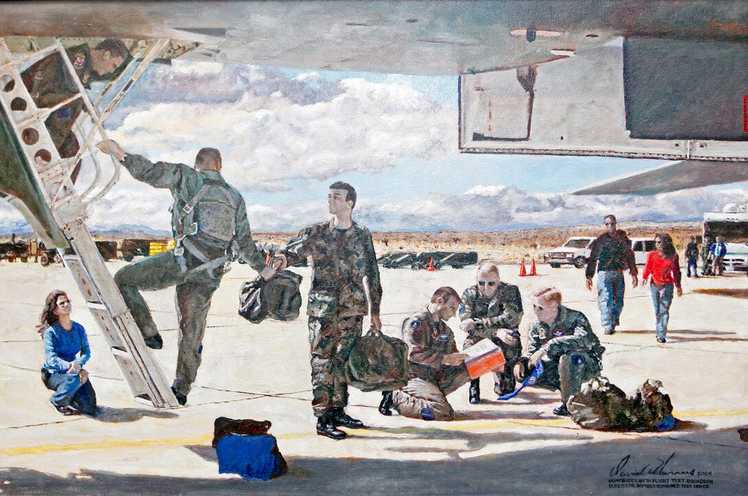 This oil painting, which is currently in the care of the 419th Flight Test Squadron, depicts a variety of Bomber Combined Test Force personnel preparing for a B-1 mission with Tech. Sgt. Chad McBunch’s image in the center of the painting handing a helmet bag to a B-1 pilot. The oil painting embodies the history, unity and collaboration that countless engineers, contractors, government employees and crew chiefs, like Sergeant McBunch, have provided to the Bomber Combined Test Force over the years. (U.S. Air Force photo by Jet Fabara) 