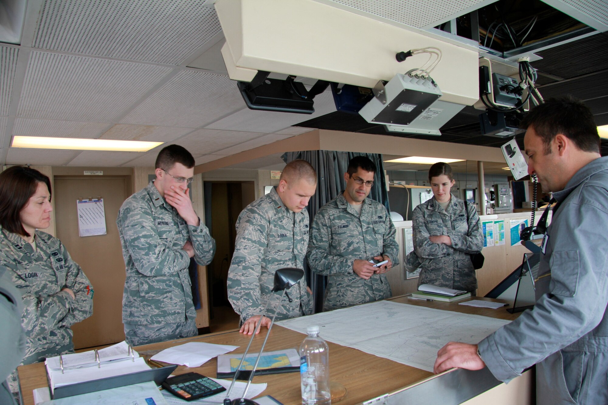 Jeff Hall (right), the incoming first mate on the USNS Soderman (T-AKR 317), explains how ships still use paper navigation charts as backups to the ship’s Global Positioning System, to (left to right) Capt. Rebecca Logan, 2nd Lt. Dan Musleve, 2nd Lt. David Loska, 2nd Lt. Andrew Palmer and Capt. Juliana D’Amore, all from the 628th Logistics Readiness Squadron. The Airmen are members of the Charleston Logistics Officer Association which toured the ship March 22, 2013, at Joint Base Charleston – Weapons Station, S.C. The Logistics Officer Association is comprised of Air Force maintenance and Logistics Readiness officers and civilians from the JB Charleston. They toured the Soderman to get a glimpse of the diversity of Charleston’s logistics capabilities.  The Soderman is a 950 foot, large, medium speed roll-on/roll-off ship that can carry the equivalent of 225 C-17 loads of cargo. It is one of eight Watson-class ships that are pre-positioned around the globe with nearly everything an Army or Marine contingent needs to begin operations. The ships return to port in the United States every one to three years, and Joint Base Charleston is the sole restocking point for the ships. (U.S. Air Force photo / 1st Lt. Adrianne Schilling

