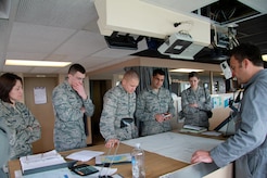 Jeff Hall (right), the incoming first mate on USNS Soderman (T-AKR 317), explains how ships still use paper navigation charts as backups to the ship’s Global Positioning System, to (left to right) Capt. Rebecca Logan, 2nd Lt. Dan Musleve, 2nd Lt. David Loska, 2nd Lt. Andrew Palmer and Capt. Juliana D’Amore, all from the 628th Logistics Readiness Squadron. The Airmen are members of the Charleston Logistics Officer Association which toured the ship March 22, 2013, at Joint Base Charleston – Weapons Station, S.C. The Logistics Officer Association is comprised of Air Force maintenance and Logistics Readiness officers and civilians from JB Charleston. They toured the Soderman to get a glimpse of the diversity of Charleston’s logistics capabilities. The Soderman is a 950 foot, large, medium speed roll-on/roll-off ship that can carry the equivalent of 225 C-17 loads of cargo. It is one of eight Watson-class ships that are pre-positioned around the globe with nearly everything an Army or Marine contingent needs to begin operations. The ships return to port in the United States every one to three years, and Joint Base Charleston is the sole restocking point for the ships. (U.S. Air Force photo / 1st Lt. Adrianne Schilling)

