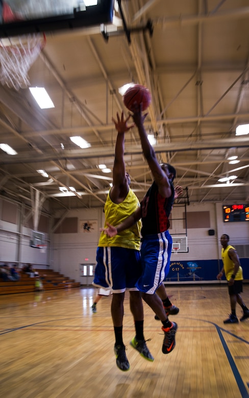 Todd Tolbert, 628th Logistics Readiness Squadron, attempts a layup while Jeston Freeman, 628th Civil Engineer Squadron player, attempts to block the shot during the Intramural Basketball Championship March 25, 2013, at Joint Base Charleston - Air Base, S.C. The 628th CES beat the 628th LRS 48 to 30 to become JB Charleston's basketball champions. (U.S. Air Force photo/ Senior Airman George Goslin)