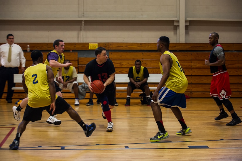 Robert Degregorio, 628th Logistics Readiness Squadron, looks to pass the ball to a teammate during the Intramural Basketball Championship March 25, 2013, at Joint Base Charleston - Air Base, S.C. The 628th CES beat 628th LRS 48 to 30 to become JB Charleston's basketball champions. (U.S. Air Force photo/ Senior Airman George Goslin)