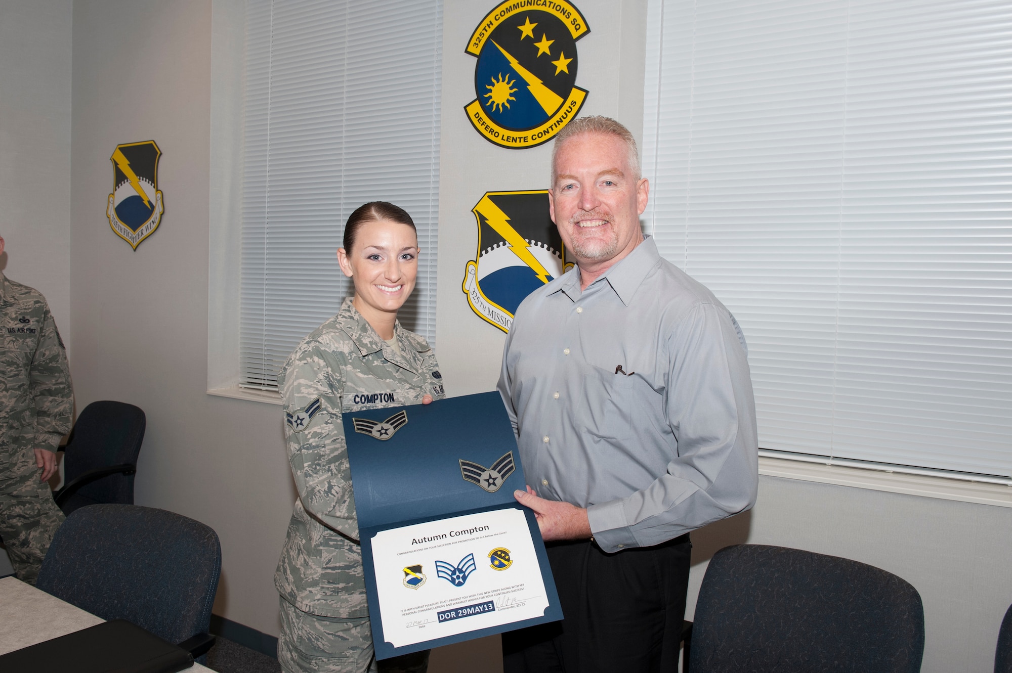 Airman 1st Class Autumn Compton, 325th Communications Squadron radio frequency technician, is notified of her below-the-zone promotion by Mr. Dan Moran, 325th CS deputy director, March 27. The BTZ program allows those in the rank of Airmen 1st Class to be promoted to Senior Airmen six months before they normally would. (U.S. Air Force photo by Lisa Norman)