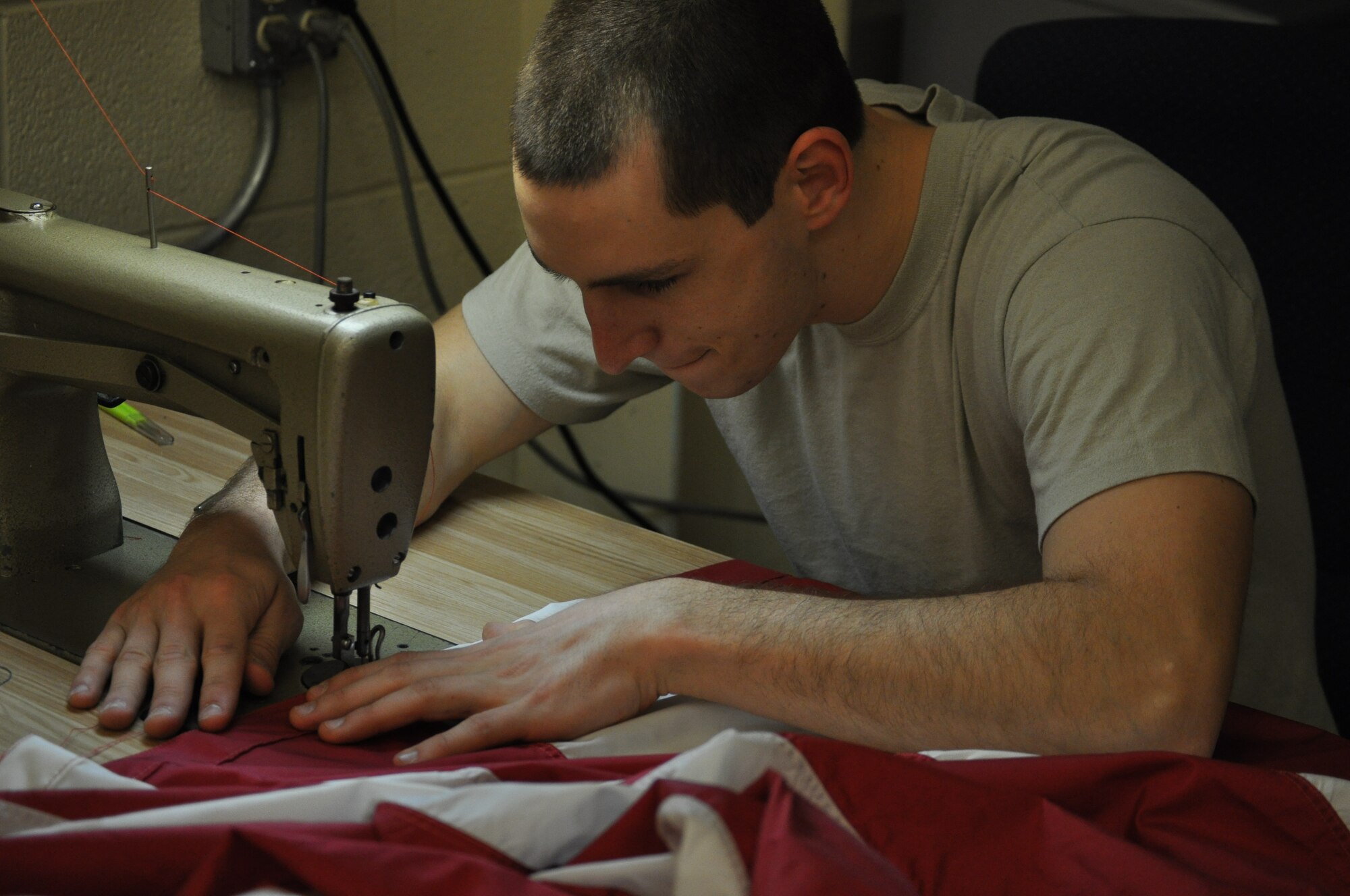 Airman 1st Class Tomas Mitchell, 325 Operations Support Squadron aircrew flight equipment technician, repairs a base flag on March 21 in Hanger 5 on Tyndall Air Force Base. He and his colleagues are tasked with the repair of the flags on base in an effort to keep Tyndall’s flags in good shape and save the funds a replacement flag would cost. (U.S. Air Force photo by Airman 1st Class Alex Echols)