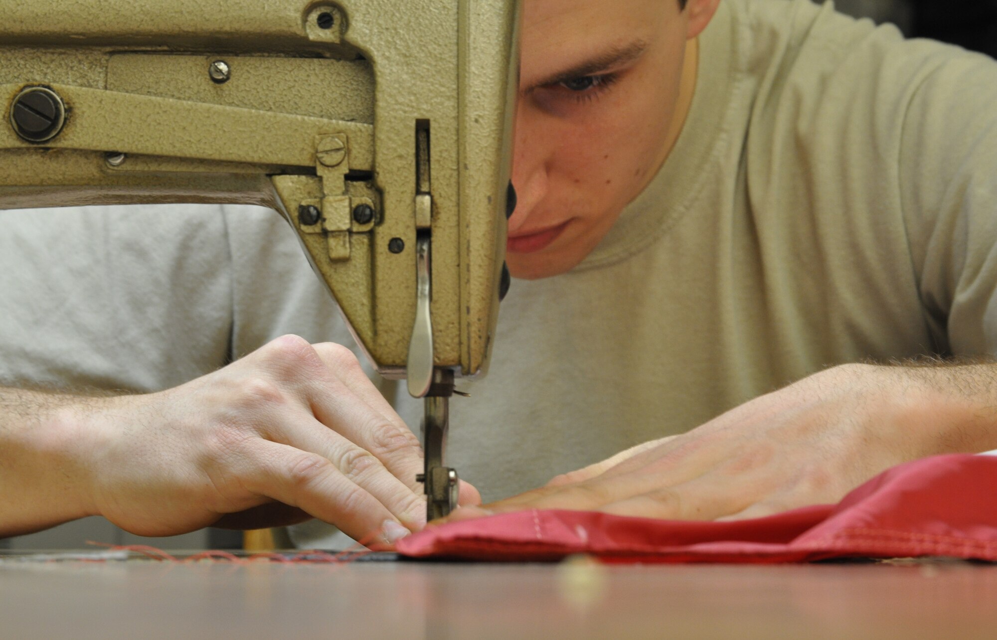 Airman 1st Class Tomas Mitchell, 325 Operations Support Squadron aircrew flight equipment technician, repairs a base flag on March 21 in Hanger 5 on Tyndall Air Force Base. He and his colleagues are tasked with the repair of the flags on base in an effort to keep Tyndall’s flags in good shape and save the funds a replacement flag would cost. (U.S. Air Force photo by Airman 1st Class Alex Echols)