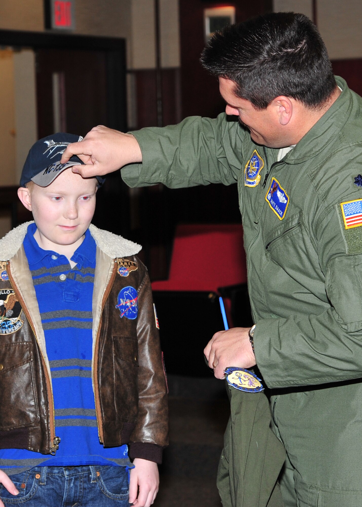 Micah Wemmer’s, honorary 22nd Operations Support Squadron “Mighty Eagle,” receives a baseball hat from Lt. Col. Martin Daack, 22nd OSS commander, March 25, 2013, McConnell Air Force Base, Kan. Micah was chosen for the “Pilot for a Day” program through a partnership with Wesley Medical Center, Wichita, Kan. The intent of this program is to assist children throughout local communities who are fighting life-threatening illnesses or conditions by providing a day of fun and allowing for a break from the routine doctor and hospital visits. (U.S Air Force photo/Senior Airman Katrina M. Brisbin)