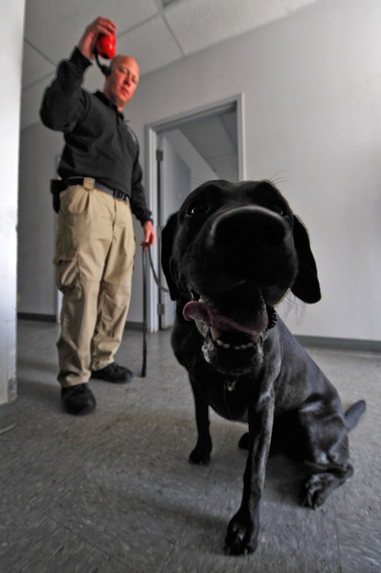 Wyatt Rhoden, Transportation Security Administration, rewards his K-9 for finding a training device March 20, 2013, at a training facility on Buckley Air Force Base, Colo. Rhoden and his K-9, Qualls, participated in a K-9 training exercise hosted by the 460th Security Forces Squadron. Qualls is named after Lance Cpl. Louis Qualls who was killed in action Nov. 16, 2004, in Fallujah, Iraq. (U.S. Air Force photo by Airman 1st Class Riley Johnson/Released)