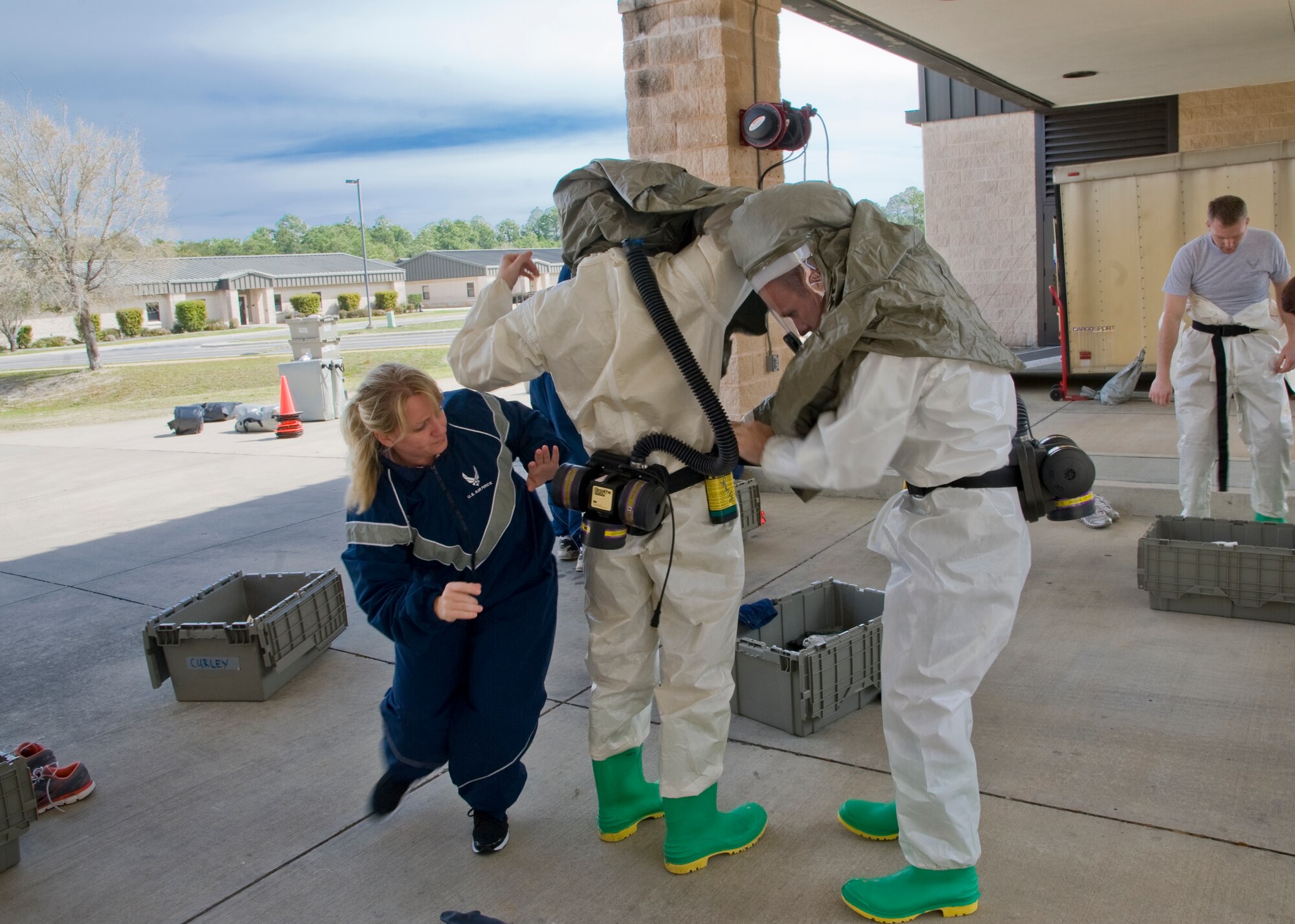U.S. Air Force Airmen race to put on contamination zone gear as fast as possible during the In-Place Patient Decontamination Exercise on Hurlburt Field, Fla. March 21, 2013. Every valve must be checked on the suits be for departure to assure medical personnel stays contamination free. (U.S. Air Force photo/ Airman 1st Class Nigel L Sandridge)