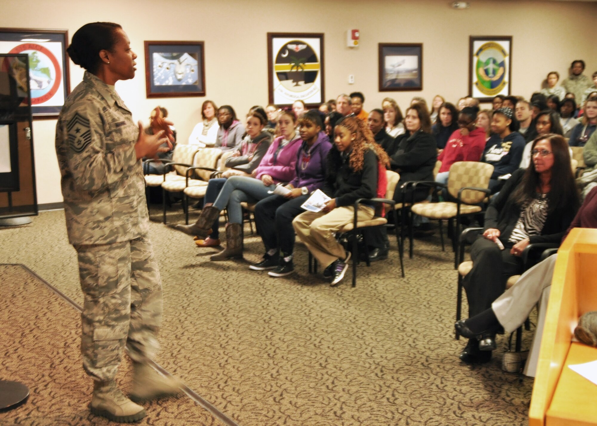 Chief Master Sgt. Gigi Manning, Command Chief Master Sergeant of the 315th Airlift Wing, speaks to local school girls about the wing and the types of jobs women do in the military, at Joint Base Charleston, SC, March 26. Nearly 140 eighth and ninth grade-girls from Charleston area schools visited to learn about jobs in aviation. (U.S. Air Force photo/Tech. Sgt. Scott Mathews)