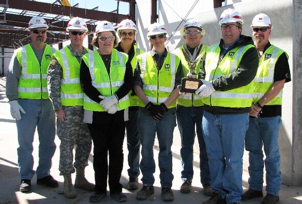 Wearing all of the proper safety gear, hard hats, safety glasses, safety vests, gloves, and steel toe boots, the employees of the Pantex Resident Office receive the 2012 Eagle Eye Construction Safety Program Award for Construction Office of the Year, March 8, 2013 at the High Explosives Pressing Facility construction site, Pantex Plant, Texas.