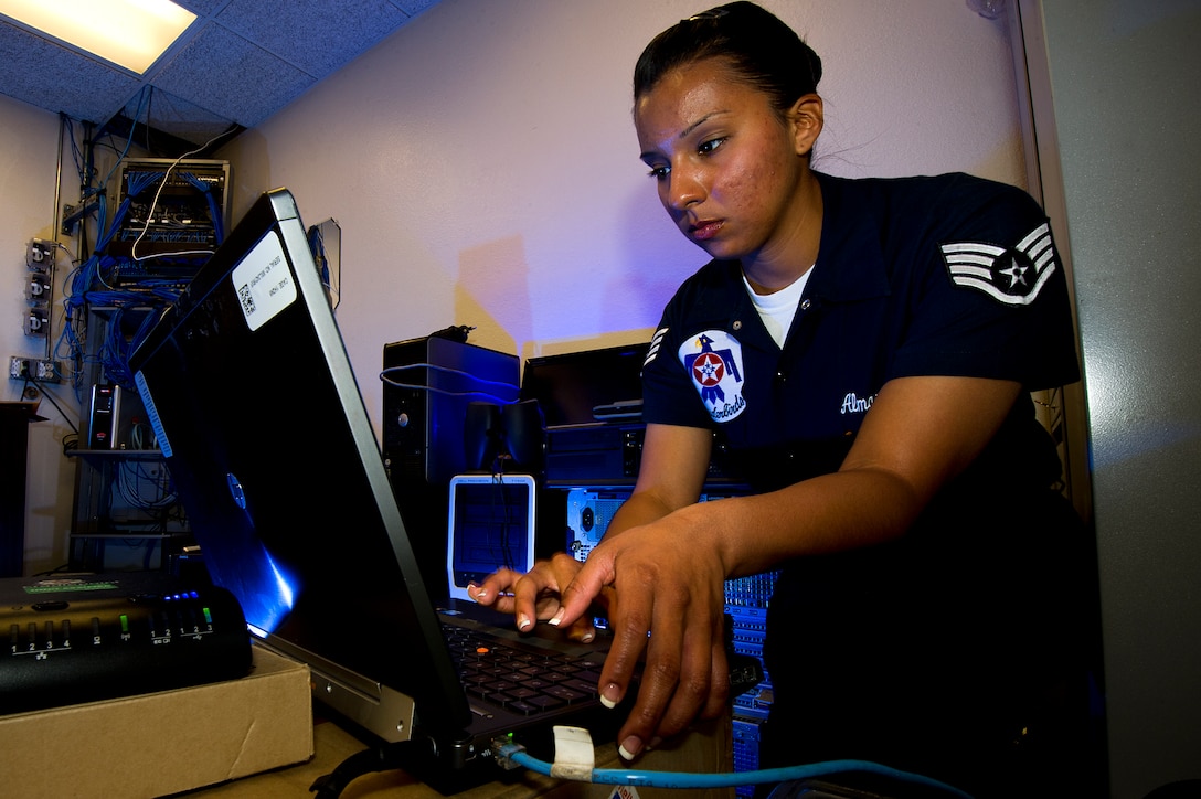 Air Force Staff Sgt. Laura Almazan configures a laptop for use in the client support administrator's work room on Nellis Air Force Base, Nev., March 13, 2013. Almazan, a knowledge operations specialist, is one of 13 females assigned to the Air Force Thunderbirds air demonstration squadron for the 2013 show season.