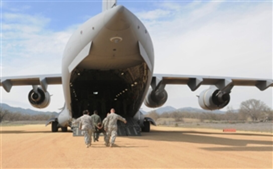 Soldiers with the 801st Combat Support Hospital rehearse loading a casualty aboard a U.S. Air Force C-17 Globemaster III as part of an U.S. Army Reserve training exercise at Fort Hunter Liggett, Calif., on March 19, 2013.  The joint exercise drew more than 3,500 soldiers, sailors and airmen from across the United States.  