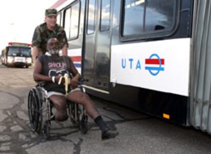 A National Guardsman assists a Hurricane Katrina evacuee.