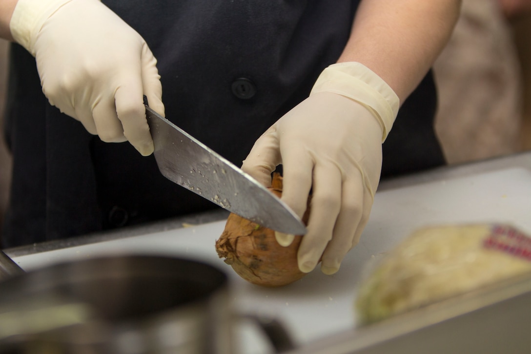 Lance Cpl. Mallorie Adams, a Claremore, Okla., native, and combat cook assigned to the 26th Marine Expeditionary Unit (MEU), cuts an onion during a Steel Chef competition aboard the USS Kearsarge (LHD 3) while at sea March 23, 2013. In the Steel Chef competition, three Marines cook against three Sailors to see who can create the best meal in less than 90 minutes. The 26th MEU is deployed to the 6th Fleet area of operation. The MEU operates continuously across the globe, providing the president and unified combatant commanders with a forward-deployed, sea-based, quick-reaction force. The MEU is a Marine Air-Ground Task Force capable of conducting amphibious operations, crisis-response and limited contingency operations. (U.S. Marine Corps photo by Cpl. Kyle N. Runnels/Released)