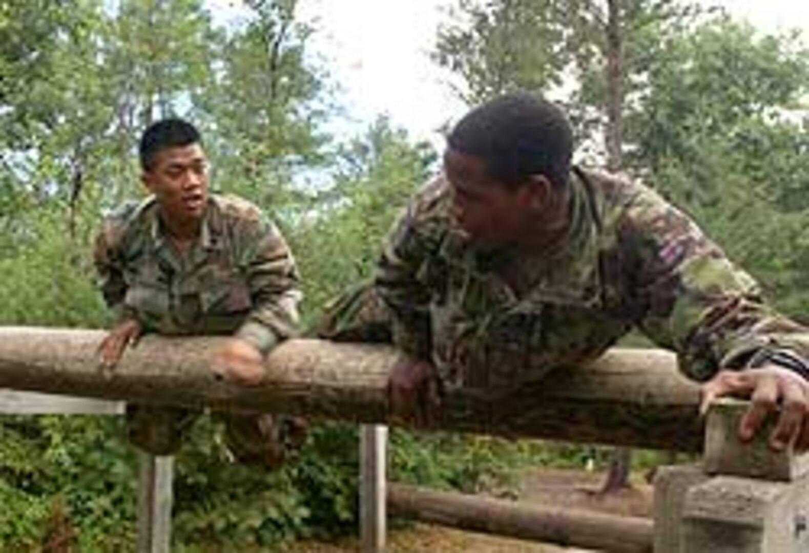 Spc. Dan Bounnavong, Troop C, 2nd Squadron, 106th Cavalry, and a British Soldier with Number 7 Company, Coldstream Guards go over an obstacle together as part of a training exercise between the United States and Great Britain at Ft. McCoy, Wis. in July. As part of transformation, the new unit is able to participate in a variety of new training opportunities.