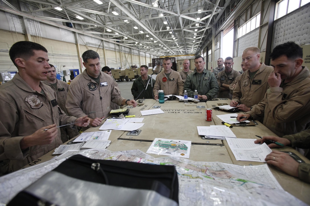 Capt. Samuel Kunst, left, a pilot with Marine Heavy Helicopter Squadron 366, briefs the pilots and crew before executing an artillery raid training exercise at Fort Bragg, N.C., March 13. In their facilities on Fort Bragg, HMH-366 and HMH-464 used low-tech expeditionary planning without the luxury of Power Point and projectors to create their flight plans. An artillery raid is a concept in which helicopters lift howitzers to forward firing points to gain a greater range advantage over the enemy. Helicopters then pull the artillery out before the enemy can retaliate.