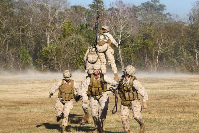 Marines of Company C, 2nd Reconnaissance Battalion, run as they are lowered from a Marine Heavy Helicopter Squadron 464 CH-53E Super Stallion aboard Marine Corps Base Camp Lejeune, March 13. The reconnaissance Marines were being inserted and extracted by HMH-464 using special purpose insertion and extraction rigging.