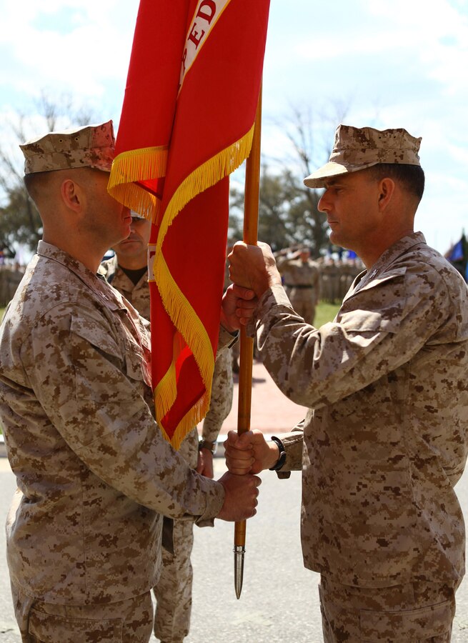 Col. Frank Donovan passes the 24th Marine Expeditionary Unit battle colors to Col. Scott F. Benedict, the incoming commanding officer for the 24th MEU, during a change of command ceremony aboard Camp Lejeune, N.C., March 21, 2013. Col. Benedict is responsible for leading the unit through its next training cycle and deployment scheduled for 2014. (Official USMC Photo by Cpl. Michael Petersheim/Released)