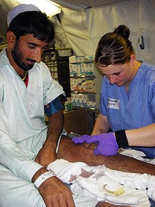 Spc. Jessica Guzzetti, a Task Force Talon medic from the 1-183rd Aviation Battalion from Boise, Idaho, tends to the needs of a local at a free clinic in Afghanistan.