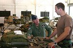 Royal Auxiliary Air Force Warrant Officer Matt Dillon talks with Staff Sgt. Kenneth Dahl, a 189th Aerial Port Flight air transportation specialist, about cargo the Arkansas Air National Guardsman helps prepare for airdrop.