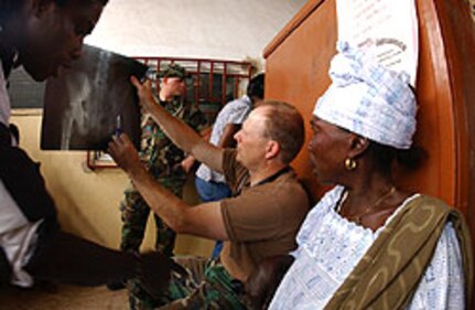 U.S Air Force flight surgeon Lt. Col. Bryan DeLage (119th Medical Group) shows patient Amena Salifu the x-ray of her hip fracture at the Mallam-Atta Market Government Clinic as part of the Medflag 2006 joint force humanitarian medical assistance exercise Accra, Ghana Sep. 13. Amena Salifu walked to the clinic on the broken hip to be examined. The North Dakota National Guard medical group members and support personnel are in Ghana as part of Medflag 2006, which is a U.S. military medical exercise that is geared toward gaining and providing training and experience in management of world health problems, sharing of medical information and techniques with African host countries, and providing humanitarian civic assistance to host nation civilian populations as good will ambassadors of the United States.