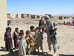 Capt. Jason K. Piercy, 147th Field Artillery, South Dakota Army National Guard, poses with local children during a health assistance visit on Wednesday, Oct. 4, in the village of Robat, Afghanistan.