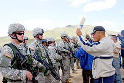 Oregon National Guard Soldiers, from B Company, 2nd Battalion, 162nd Infantry, Sgt. Brandon Hern (left), of Corvallis, and Pvt. 1st Class Geoffery Thoma (right), of Albany, simulate controlling a crowd of a villagers at a food distribution site during Distribution training Aug. 16, at Five Hills Training Center, near Ulan Bator, Mongolia, for Khaan Quest 2006, UN peacekeeping exercise.